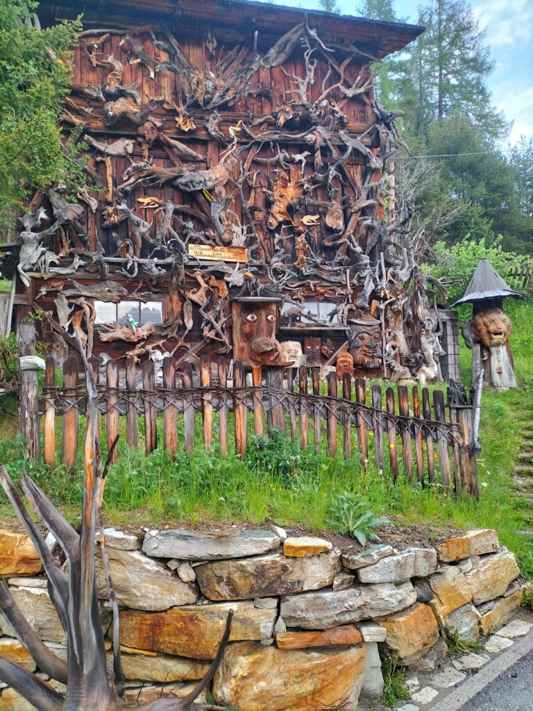 escursioni per famiglie in alto adige longiaru villaggio degli alpinisti casa in legno con statue in legno 